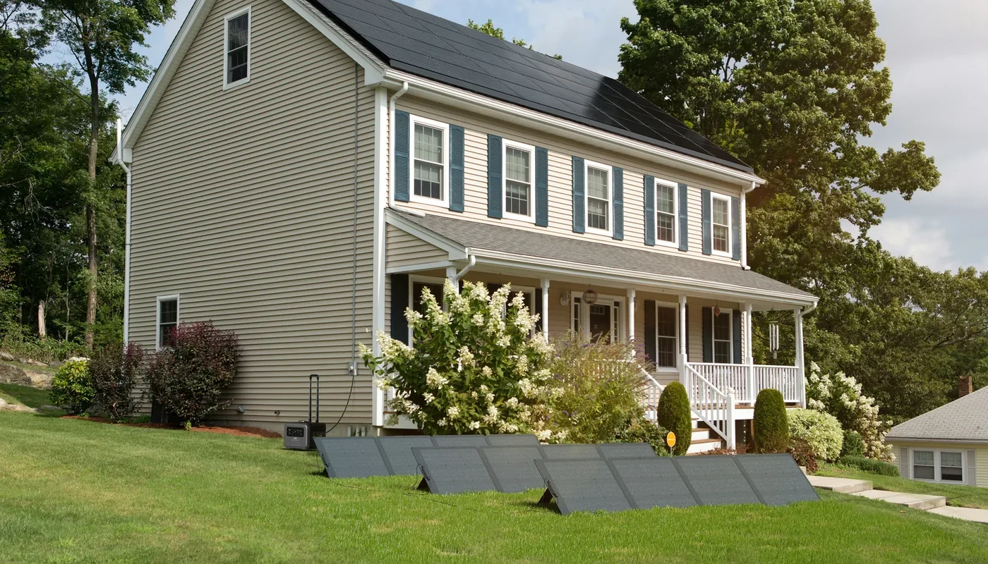 Home with rooftop solar and a portable battery system set up on the lawn