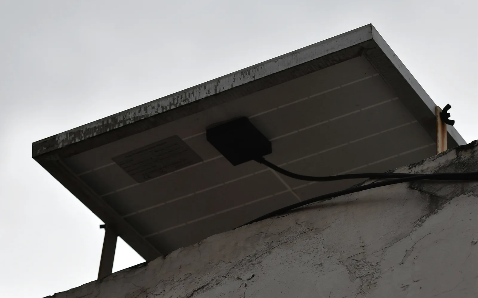 Rooftop solar panels under heavy clouds, emphasizing that panels alone do not provide outage backup