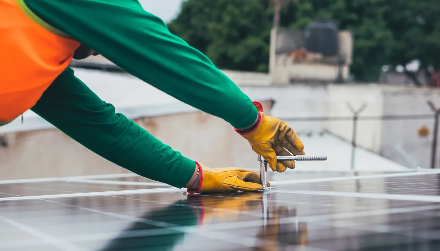 Solar technician tightening photovoltaic panel hardware with a hand tool