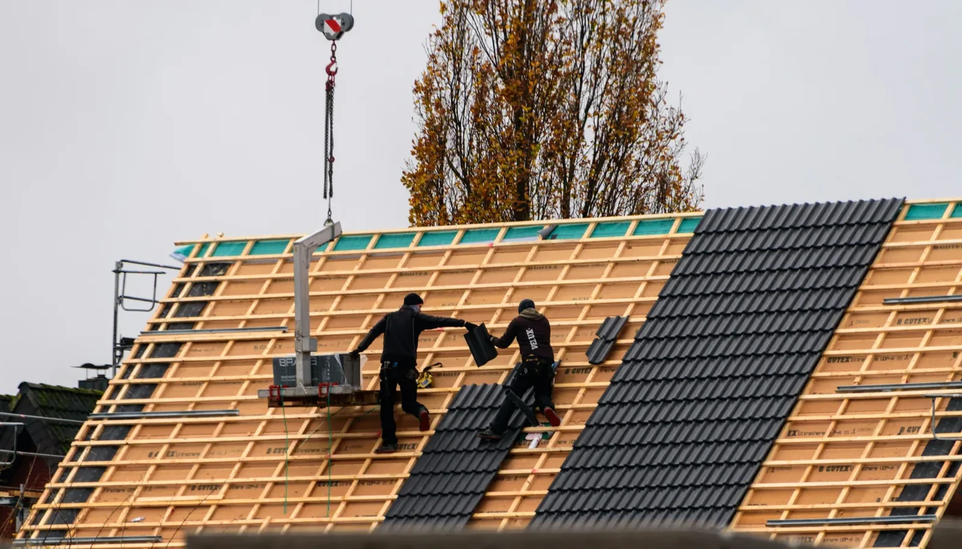 Roofing crew completing weatherproofing work connected to solar installation warranties