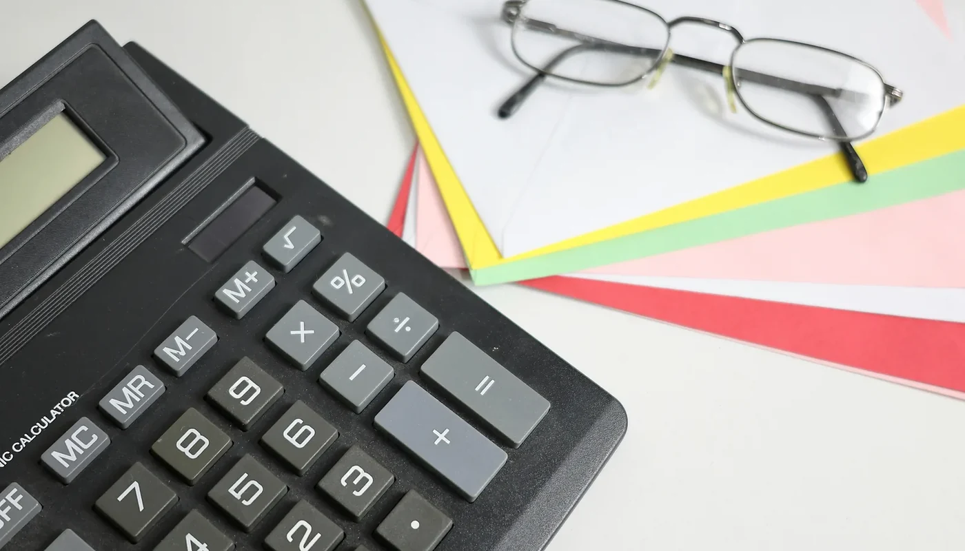 Calculator and planning papers used to evaluate a solar payback period